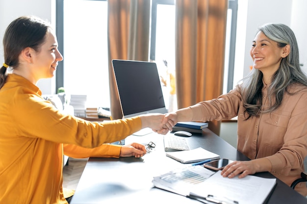 Foto oficina de mujer de negocios de mujer asiática da la mano sonrisas