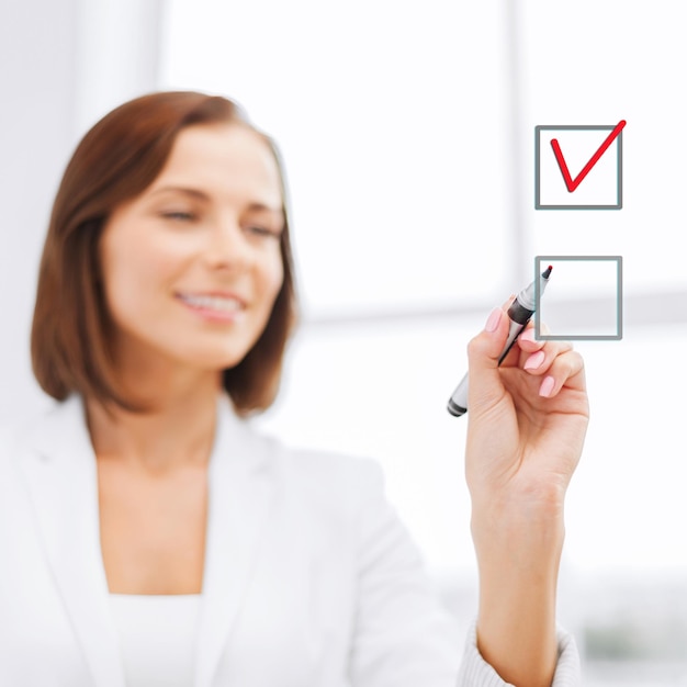 Foto oficina, negocios, concepto de tecnología - mujer de negocios escribiendo algo en el aire con marcador