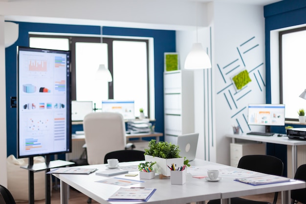 Oficina de negocios de puesta en marcha vacía, acogedora sala de empresa luminosa con mesa de conferencias lista para la lluvia de ideas, diseño moderno para sala de reuniones