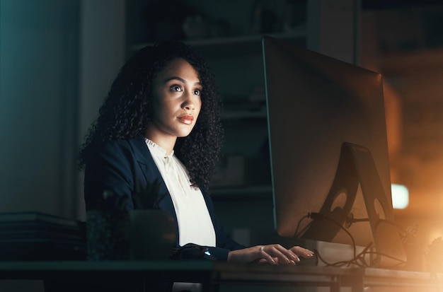 Oficina nocturna y mujer negra en la computadora para el informe de gestión de proyectos empresariales y documento en línea Horas extraordinarias de trabajadores corporativos y mujeres enfocadas que trabajan en la planificación estratégica y la investigación de sitios web