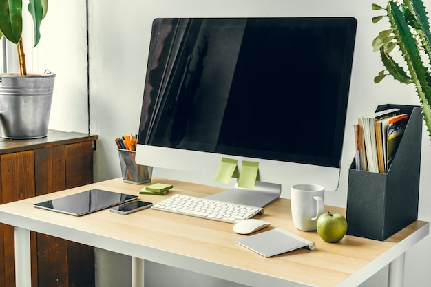Oficina o espacio de trabajo en el hogar, monitor de computadora con pantalla negra en la mesa de oficina con suministros