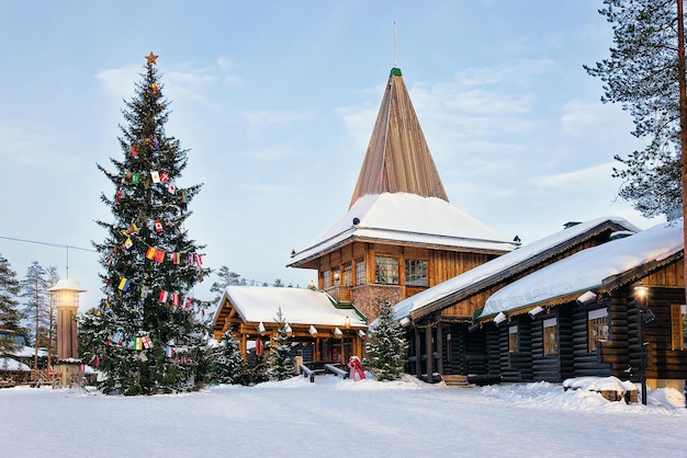 Oficina de Santa Claus en Santa Village con árbol de Navidad, Laponia, Finlandia, en el Círculo Polar Ártico en invierno. gente en el fondo