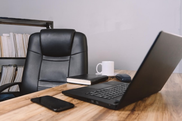 Foto una oficina con una silla un escritorio una computadora portátil un teléfono un cuaderno y una taza de café concepto de fondo