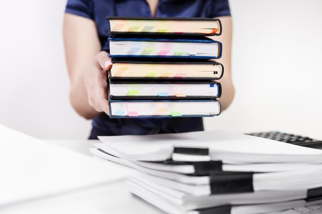 Foto un oficinista cambia una pila de cuadernos con marcadores de colores