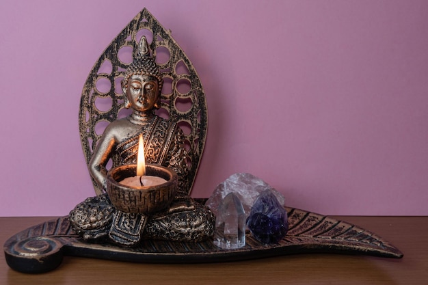 Ofício de Buda com uma vela acesa e pedras preciosas
