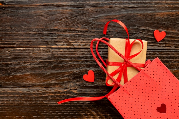 Ofício de papel Caixa de presente com laço de fita vermelha, saco de papel e corações vermelhos. Conceito festivo para o dia dos namorados, dia das mães ou aniversário.