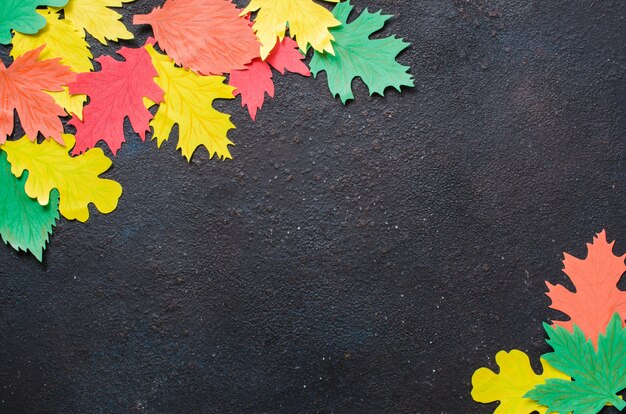 Ofício de papel, folhas de outono vermelhas e amarelas. Vista superior no plano leigos no fundo escuro do concreto.