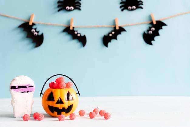 Foto ofícios de halloween, abóbora alaranjada, mamã e aranha, bastão na tabela de madeira.