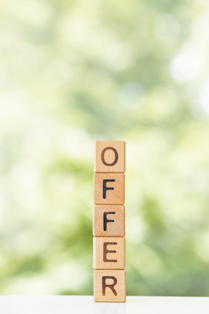 Ofrecer palabra en cubos de madera sobre un fondo verde