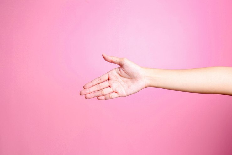 Foto ofrecimiento de mano estrechamiento de mano aislado sobre fondo rosa concepto de saludo gesto de mano