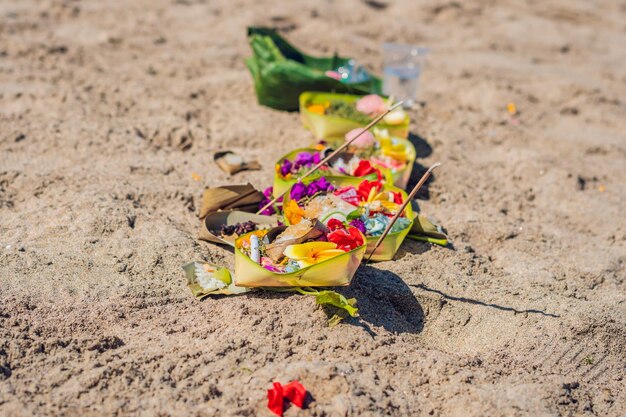 Ofrendas y regalos hindúes a dios en la playa en Bali, Indonesia