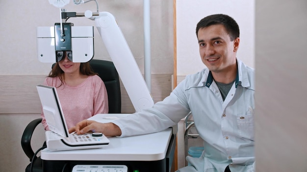 Oftalmología joven comprobando su agudeza visual con un equipo de optometrista mujer sonriente y el médico