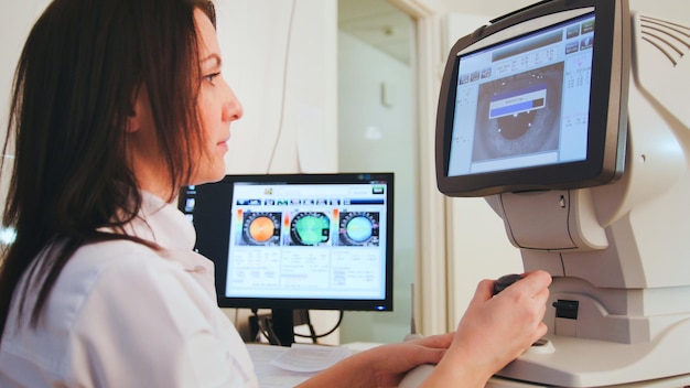 Oftalmologista em clínica de olhos fazendo diagnóstico com a visão do paciente por meio de tecnologia de computador moderna