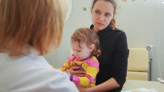 Oftalmologista - optometrista verifica a visão da menina, horizontal