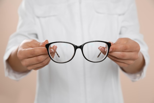 Oftalmólogo femenino con anteojos en primer plano de fondo claro