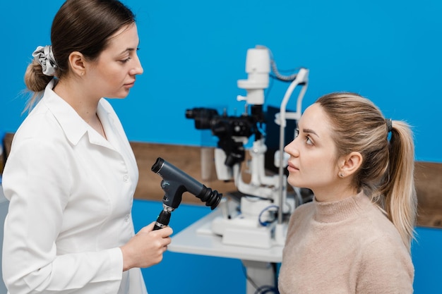 Oftalmoscopia Consulta com optometrista na clínica médica Oftalmologista examina os olhos da mulher com oftalmoscópio Oftalmologia