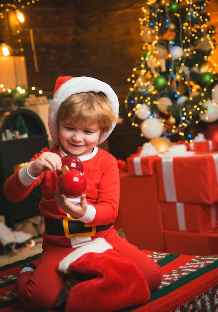 Oh, glücklicher Tag Freude und Glück Kindheitsmomente Kid Boy Santa Hold Weihnachtsgeschenk Weihnachtsstrumpf Konzept Kind fröhliches Gesicht bekam Geschenk in Weihnachtssocke Inhalt der Weihnachtsstrumpf