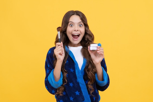 Oh meu deus, conceito de beleza natural, adolescente feliz, segura pincel de pó, cosmetologia e beleza, criança surpresa de pijama ou roupão de banho, uso de cosméticos, cuidados matinais, cuidados com a pele e maquiagem