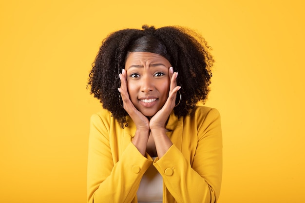 Oh, no hay retrato de dama negra mirando a la cámara y tocando las mejillas reaccionando a las noticias u ofreciendo amarillo