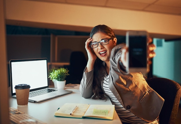 Oh, no mire la hora Captura recortada de una mujer de negocios estresada que trabaja hasta tarde en una oficina