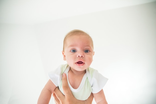 Ojo azul bebé niño siendo levantado por los brazos del padre