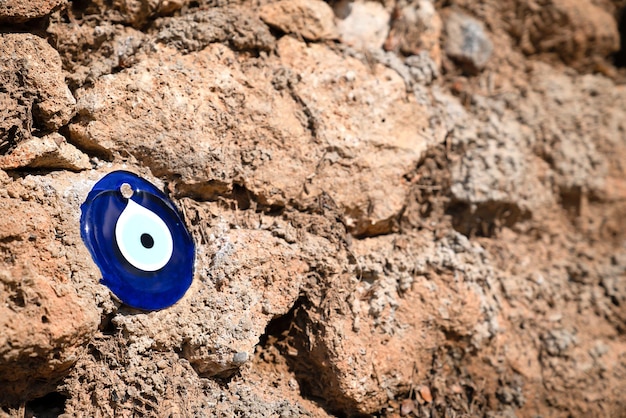 Ojo de cristal azul de Fátima sobre fondo de piedra marrón, símbolo de protección contra el mal de ojo