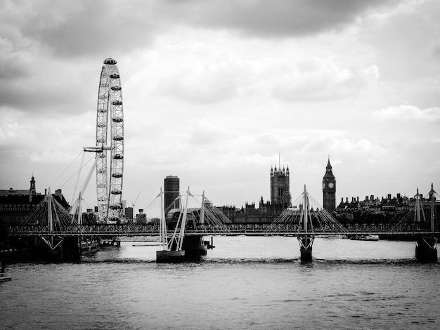 Foto ojo de londres por el río támesis contra el cielo nublado