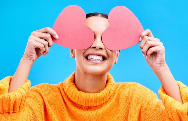 Los ojos del corazón cubren y la mujer con felicidad y emocionada por el amor día de san valentín o emoji Sonrisa feliz y persona con fondo azul aislado símbolo de papel de romance amoroso o creativo para mostrar cuidado