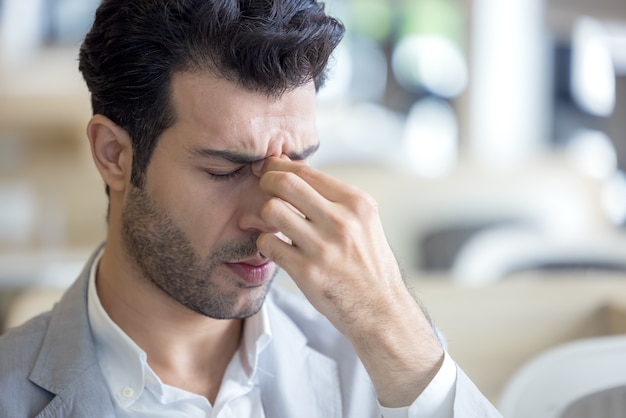 Los ojos de un joven cansado están cansados del trabajo con la computadora