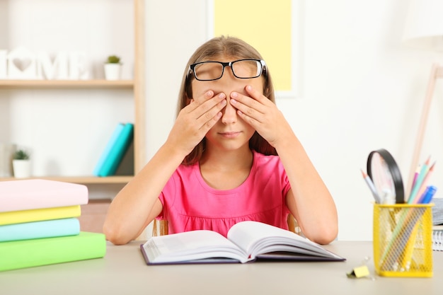 Los ojos de la niña duelen de sus gafas problemas de visión en los niños