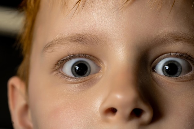 Los ojos de un niño están muy abiertos y la palabra "en la parte inferior derecha"