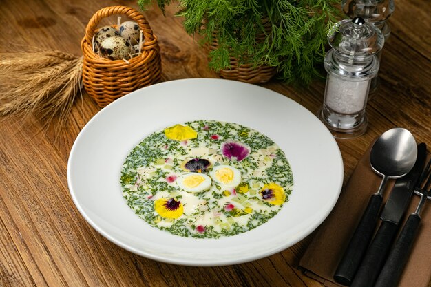 Okroshka mit grünen Radieschen gekochte Eier auf einem Holztisch