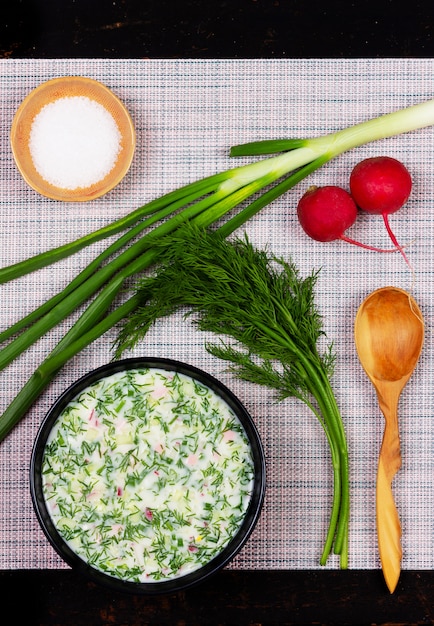 Okroshka de sopa fría de verano ruso de verduras, verduras, kvas y kéfir sobre la mesa