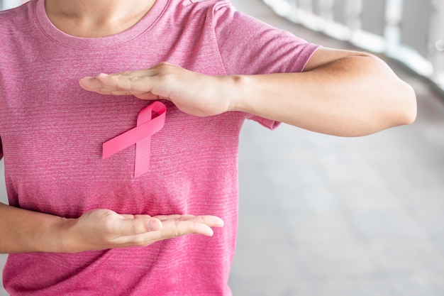 Oktober-Brustkrebs-Bewusstseinsmonat, Frau im rosa T-Shirt mit rosa Band für das Stützen der lebenden Leute und der Krankheit. Gesundheitswesen, internationaler Frauentag und Weltkrebstagskonzept