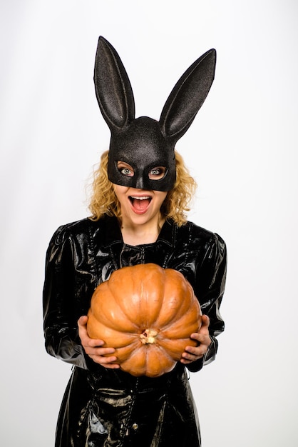 Oktober lächelnde Frau im Halloween-Häschenkostüm sexy Mädchen in der Hasenmaske mit Kürbislaterne