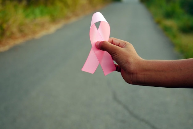 Oktober, Monat der Aufklärung über Brustkrebs. Rosa Schleifen auf dem wilden Gras