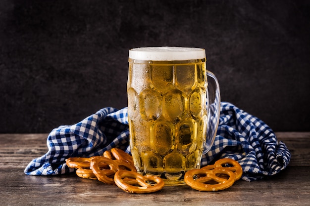 Oktoberfest cerveja e pretzel na mesa de madeira.