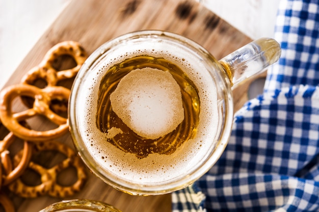 Oktoberfest cerveza y pretzel en vista de mesa de madera blanca