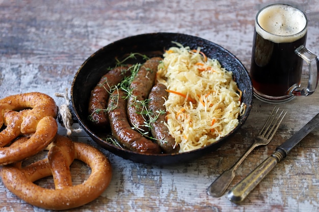 Oktoberfest comida. Salchichas bávaras calientes con chucrut en una sartén. Deliciosa comida del festival de la cerveza