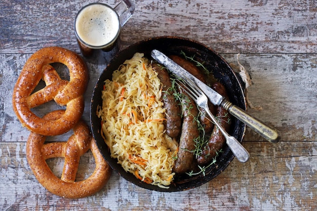 Oktoberfest comida. Salchichas bávaras calientes con chucrut en una sartén. Deliciosa comida del festival de la cerveza