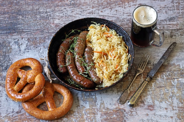 Oktoberfest Essen. Heiße bayerische Würstchen mit Sauerkraut in einer Pfanne. Leckeres Bierfestessen