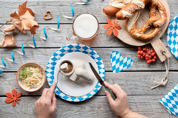 Oktoberfest traditionelles Essen und Bier, flach auf Holztisch liegen