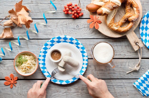 Oktoberfest traditionelles Essen und Bier, flach auf Holztisch liegen