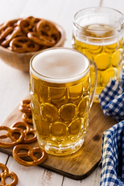 Oktoberfestbier und Brezel auf weißem Holztisch