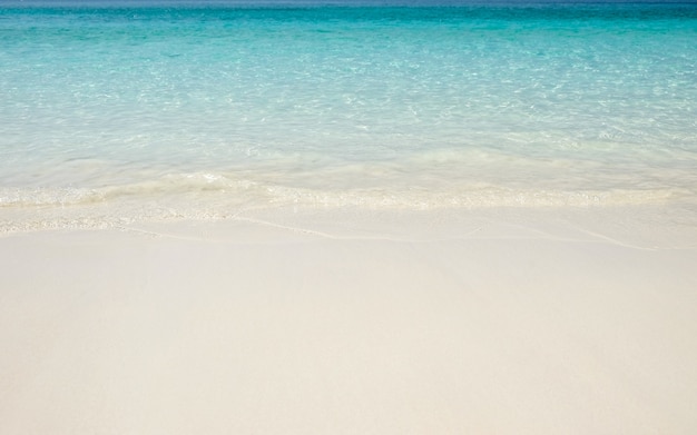 Ola azul del mar en la playa de arena. Las vacaciones de verano relajan el fondo con el espacio de la copia.