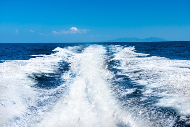 Ola del barco de crucero en la superficie del agua y el horizonte con mar azul