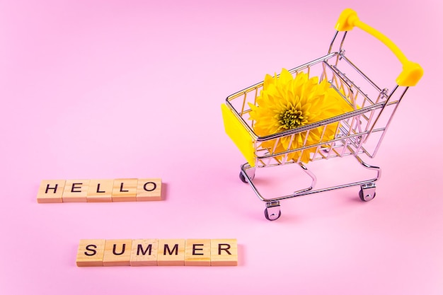 Olá carrinho de compras de verão com flores Flor amarela no fundo rosa