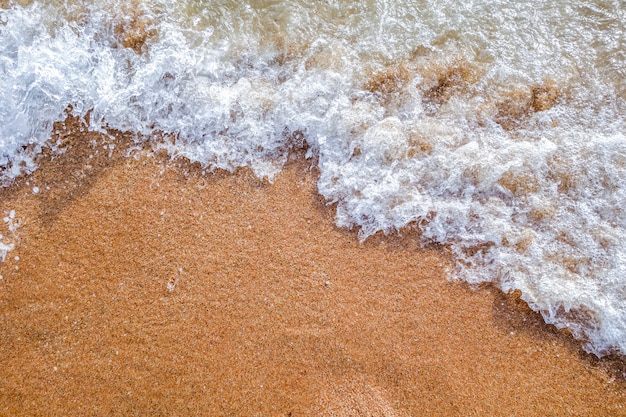 Foto ola en el fondo de la playa del océano de arena