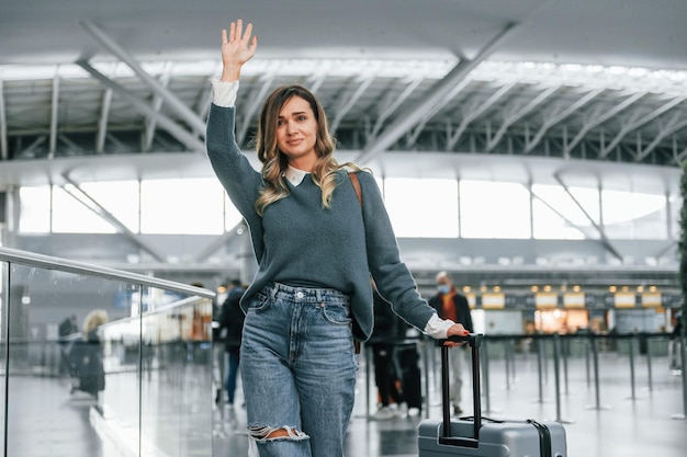 Olá gesto Jovem turista feminina está no aeroporto durante o dia