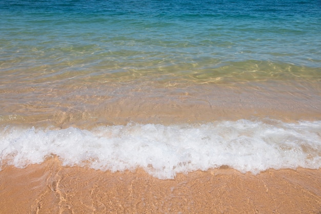 ola de mar azul en la playa de arena